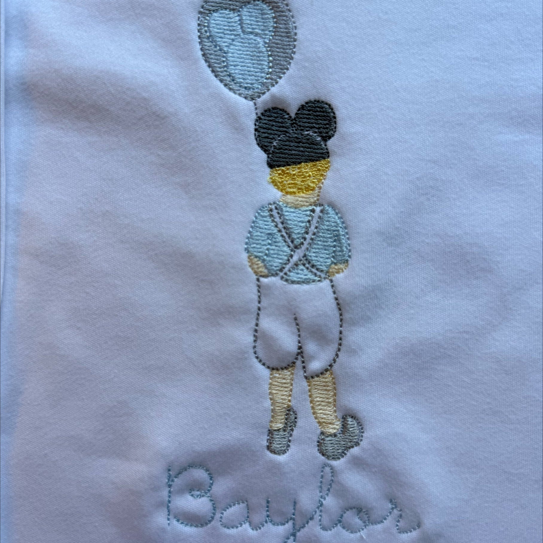 grandmillennial boy with light blue outfit and disney mickey ear balloon on a white background 